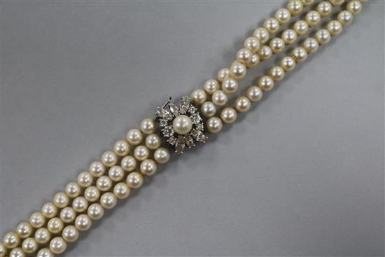 A triple strand cultured pearl choker necklace with 9ct white gold and gem set clasp, 30cm.
